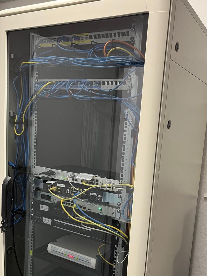 Netzwerkschrank mit Patchfeldern, verlegten Netzwerkkabeln und aktiven Komponenten