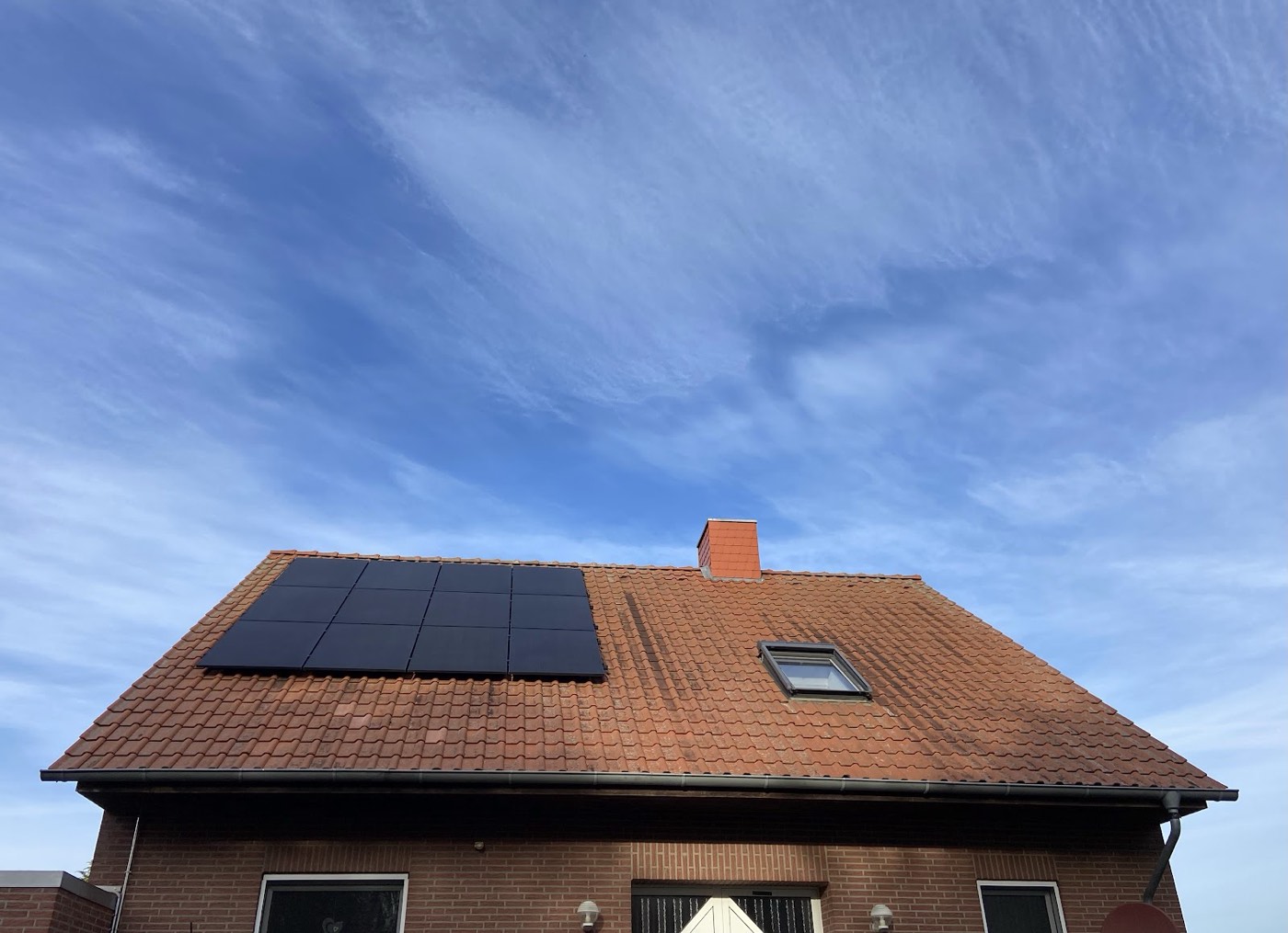 Von ML Elektrotechnik montierte Photovoltaikanlage auf einem Ziegeldach unter blauem Himmel